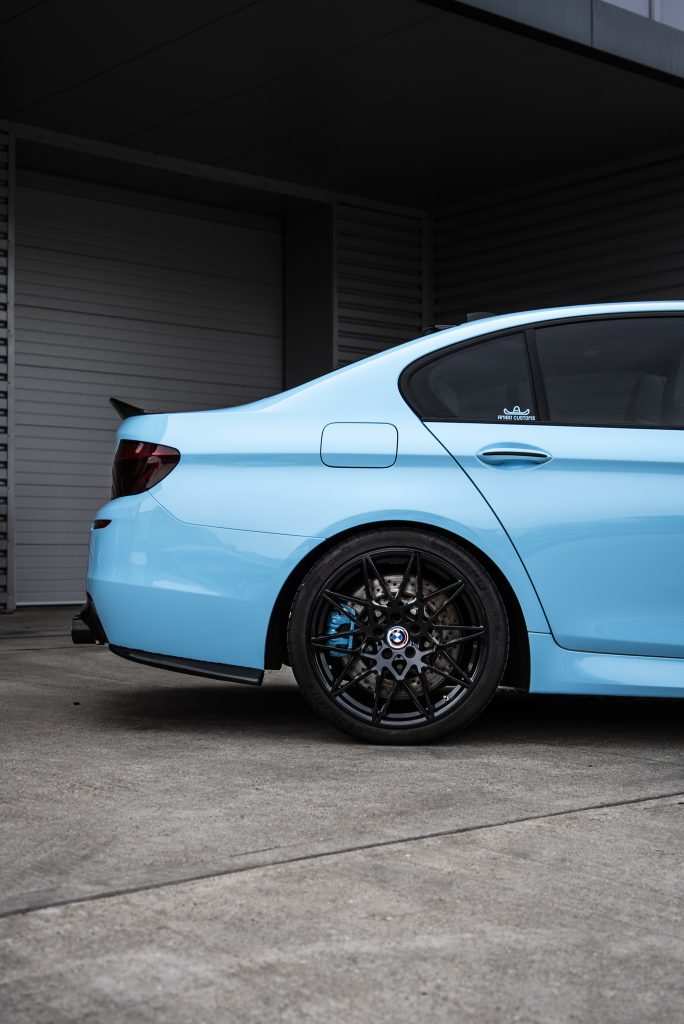 Side profile of BMW M5 in gloss sky blue